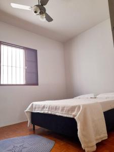 a bedroom with a bed and a ceiling fan at Casa da Vó Nair in Barra Bonita