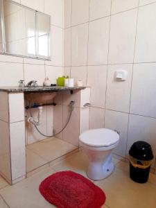 a bathroom with a toilet and a sink and a mirror at Casa da Vó Nair in Barra Bonita