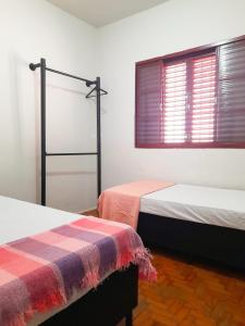 a room with two beds and a window with at Casa da Vó Nair in Barra Bonita