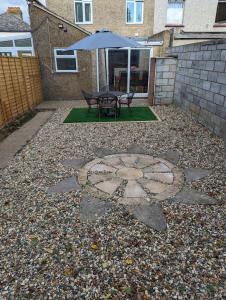 a patio with a table and an umbrella at The Crescent, 3 bed house with 2-3 parking spaces, great for contractors and family in Kent