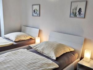 2 Betten in einem Zimmer mit zwei Lampen in der Unterkunft Gästehaus Koblenz in Koblenz