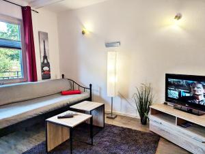 uma sala de estar com um sofá e uma televisão em Gästehaus Koblenz em Koblenz