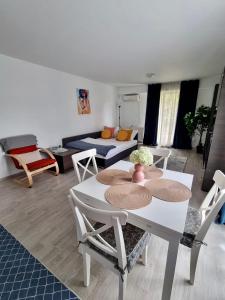 een woonkamer met een tafel en stoelen en een bank bij Fly Airport Residences & Therme-SELF CHECK-IN in Otopeni