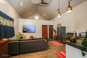 uma sala de estar com um sofá e uma cozinha em POELANI em Faaone