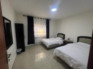 a bedroom with two beds and a window at Petra Inn House in Wadi Musa
