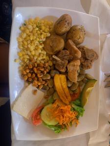 une assiette de nourriture avec des pommes de terre de maïs et d’autres denrées alimentaires dans l'établissement PONDOWASI LODGE, à Ibarra