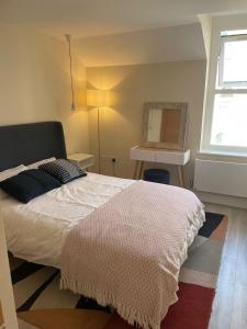- une chambre avec un grand lit et une fenêtre dans l'établissement Luxury London Oasis, à Londres