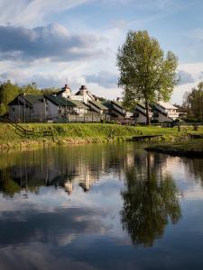 a river with houses in the background next to a town at Ośrodek wypoczynkowy Kozioł in Kolno