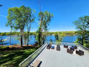 una terraza con bancos y vistas al río. en The Great Escape - Lakefront Rental with Views en Inman