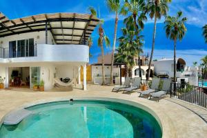 a pool in front of a house with palm trees at Private Beach Great Location Condo in El Pueblito