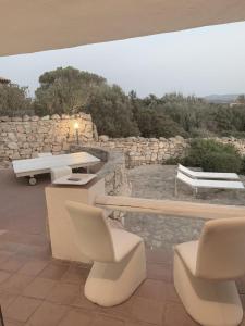 a patio with chairs and a table and a bench at I Massi 2 La Maddalena Villa con terrazze nel Villaggio Piras in La Maddalena +23 photos