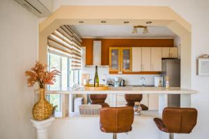 a kitchen with a counter and some chairs in a room at Apartman Marta in Zavalatica