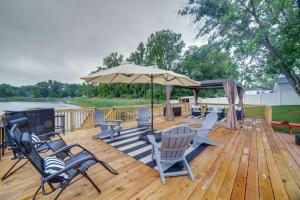 une terrasse en bois avec des chaises et un parasol dans l'établissement Lakefront Portage Home 3 Mi to Lake Michigan!, à Portage