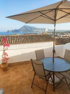 d'une table, de chaises et d'un parasol sur le balcon. dans l'établissement Casa Luz, à Altea