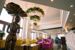 una statua di una donna in una stanza con sedie di Santa Lucia Boutique Hotel a Santa Luċija