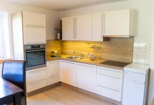 a kitchen with white cabinets and a sink at Neschtle Tarrenz in Tarrenz