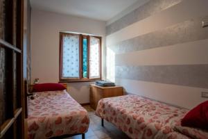 1 Schlafzimmer mit 2 Betten und einem Fenster in der Unterkunft VIVI SERENO, uno stile si vita! in Grosio