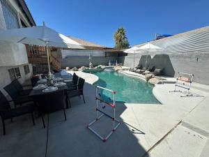 uma piscina com uma mesa e cadeiras e um guarda-sol em Bermuda Fun Oasis em Bermuda Dunes