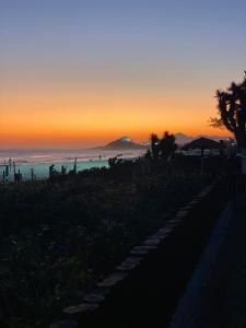 um pôr do sol na praia com o oceano em Casa do Point em Saquarema