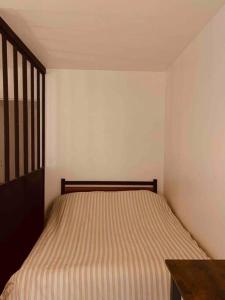 Un pequeño dormitorio con una cama en la esquina en Charmant studio avec jardin, en Eysines