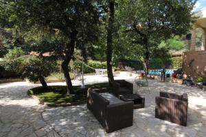 un parc avec deux chaises noires et des arbres dans l'établissement joli studio indépendant avec kitchenette, à Sauveterre