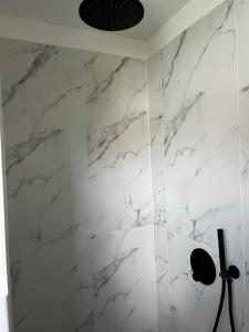 a bathroom with white marble walls and a shower at Hochwertiges Haus mit Garten mit guter Anbindung in Berlin