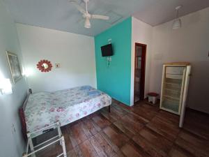 1 dormitorio con 1 cama y ventilador de techo en Recanto das Flores, en Itatiaia