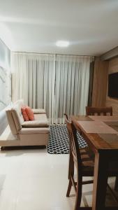 un soggiorno con divano e tavolo di Ponta Negra RN03 a Natal