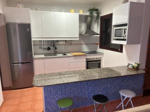 a kitchen with white cabinets and a counter with stools at Lancelot in Puerto Rico de Gran Canaria