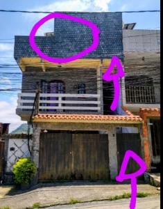 uma casa com cartazes cor-de-rosa em cima em Casa com Belas vistas - Muriqui em Mangaratiba