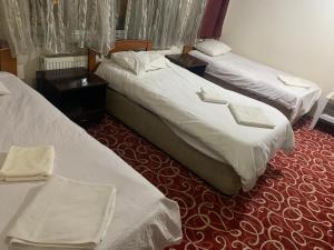 a hotel room with two beds and two tables at Altunlar erkek ögrenci yurdu in Altındağ