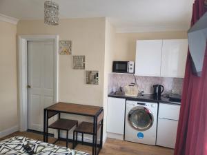 een keuken met een wasmachine en een tafel bij Lovely 1-Bed Studio in Reading in Reading