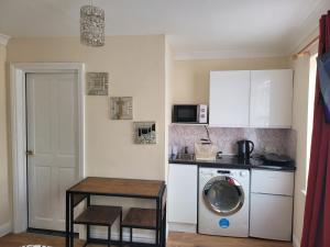 een keuken met een wasmachine en een tafel bij Lovely 1-Bed Studio in Reading in Reading
