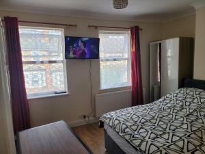a bedroom with a bed and two windows at Lovely 1-Bed Studio in Reading in Reading