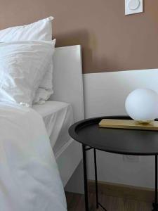 una cama con una mesa con una almohada blanca y un tazón en ella en Limoges Sud-LesCinqSuites Le Saint Laurent-DABNB, en Limoges