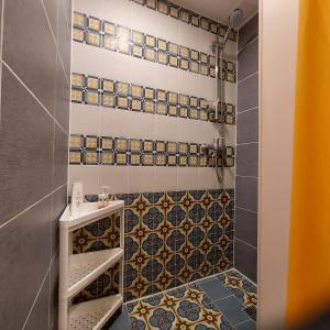 uma casa de banho com um chuveiro com azulejos azuis e brancos em Bar-celona em Vilnius