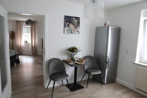 a kitchen with a table and chairs and a refrigerator at Soester Altstadt Apartment in Soest