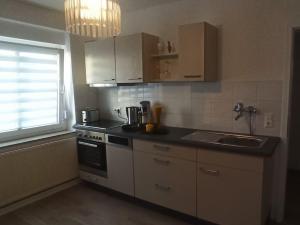 a kitchen with a stove and a sink and a window at Soester Altstadt Apartment in Soest