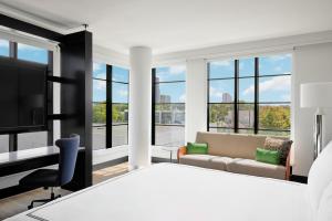 a bedroom with a large bed and a tv at The Godfrey Detroit, Curio Collection By Hilton in Detroit