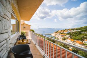 Un balcón con sillas y vistas al océano. en Apartman Marta en Zavalatica