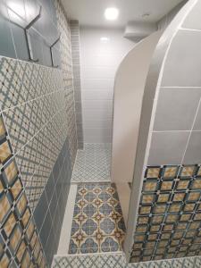 een badkamer met een inloopdouche en tegels op de vloer bij Bar-celona in Vilnius