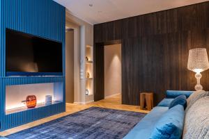 a living room with a blue couch and a television at La Dolce Vita Luxury Apartment in Rome