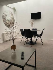 - un salon avec une table, des chaises et une télévision dans l'établissement Namur BnB, à Namur