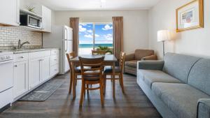 a kitchen and living room with a table and a couch at Palm Crest Resort Motel in St. Pete Beach