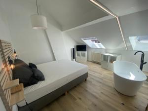 - une chambre avec un lit, une baignoire et un lavabo dans l'établissement Namur BnB, à Namur