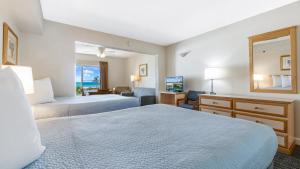 a hotel room with two beds and a living room at Palm Crest Resort Motel in St Pete Beach