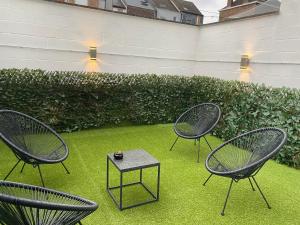 drie stoelen en een tafel op het gras bij Namur BnB in Namen