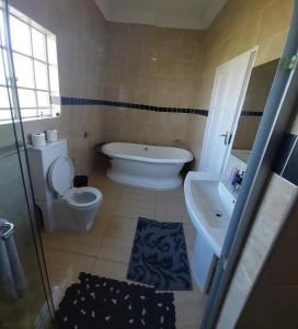 La salle de bains est pourvue de toilettes blanches et d'un lavabo. dans l'établissement 46 Charles Street, Grootfontein Country Estate.Pretoria East, à Tierpoort