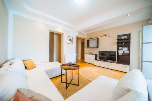 a living room with a white couch and a tv at Apartman Marta in Zavalatica