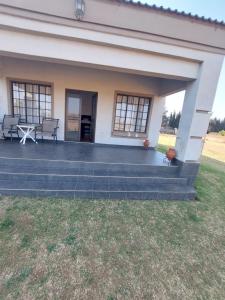 une maison avec une terrasse et une cour dans l'établissement 46 Charles Street, Grootfontein Country Estate.Pretoria East, à Tierpoort